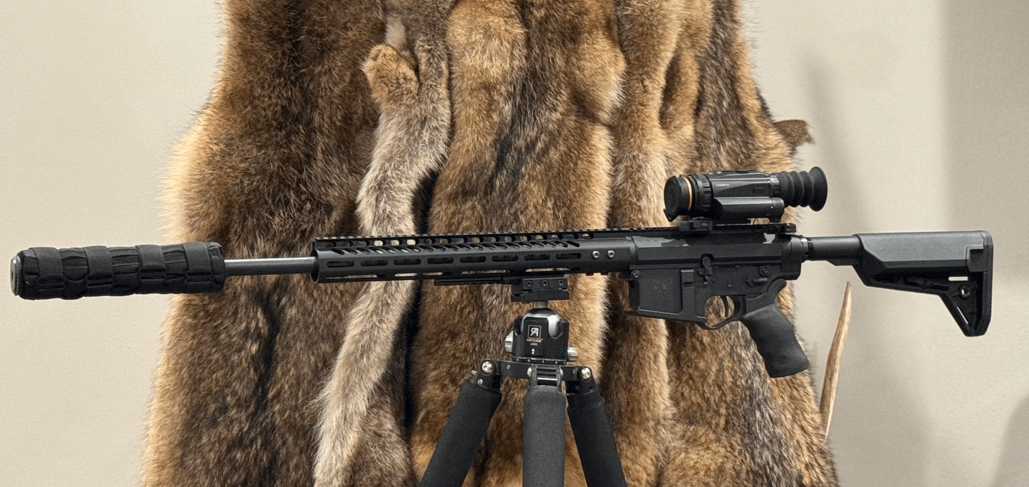 Rifle-mounted RIX STORM S3 with coyote pelt pile in the background
